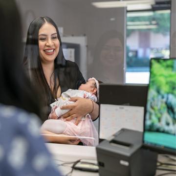 一名妇女抱着孩子在信用合作社支行